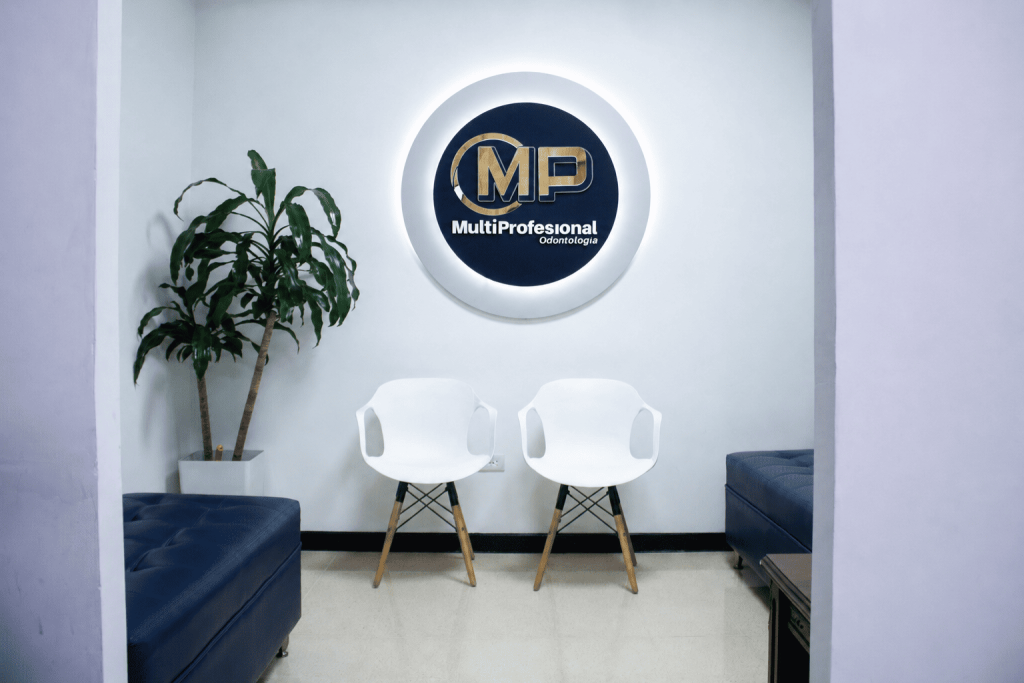 Sala de espera de MP Odontología con el logotipo de la clínica en la pared