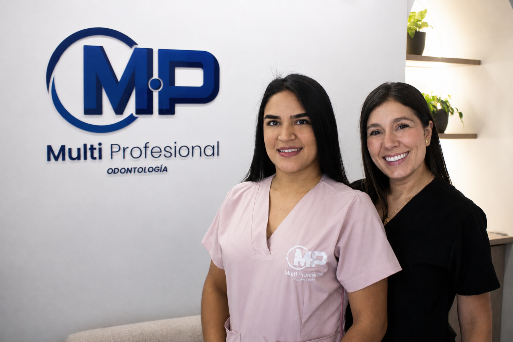 Dos profesionales de MP Odontología junto al logotipo de la clínica