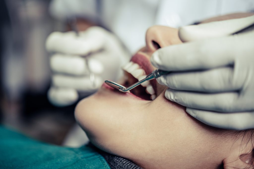 Odontólogos atendiendo a un paciente durante un tratamiento dental